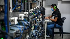 An employee inspects computers used to mine Bitcoins at the mining showroom of the Doctorminer company in Caracas on August 18, 2021.