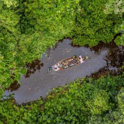 Esta vista aérea muestra una canoa recorriendo el bosque de Lokoli. - En este bosque, que lleva el nombre del río Hlan que lo atraviesa, se han contabilizado más de 241 especies de plantas y 160 de animales, entre ellas el raro mono de vientre rojo, la mangosta de los pantanos y la sitatunga. | Foto:Yanick Folly / AFP