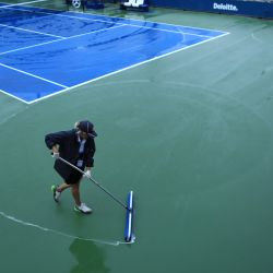 El personal de la cancha limpia la lluvia de las canchas del Centro Nacional de Tenis Billie Jean King de la USTA en Nueva York. - Los partidos en las canchas exteriores han sido aplazados por el paso de los restos del huracán Ida por la región. | Foto:Kena Betancur / AFP