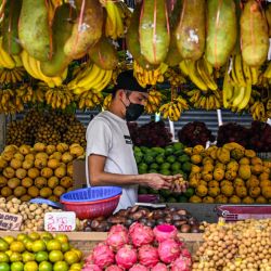 Un vendedor espera a los clientes en su puesto de frutas en Kuala Lumpur. | Foto:Mohd Rasfan / AFP