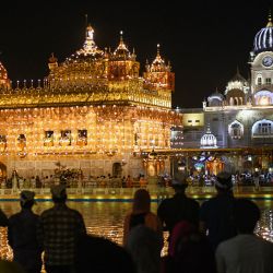 Los devotos sijs presentan sus respetos en la víspera del 417º aniversario de la instalación del Guru Granth Sahib, en el iluminado Templo Dorado, en Amritsar. | Foto:Narinder Nanu / AFP