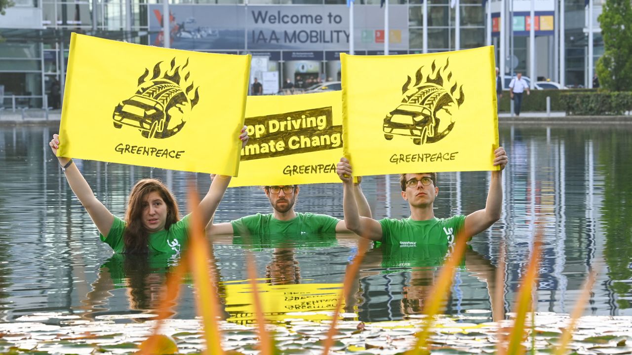 Activistas de Greenpace se sitúan en un estanque y sostienen pancartas en las que piden  | Foto:Christof Stache / AFP