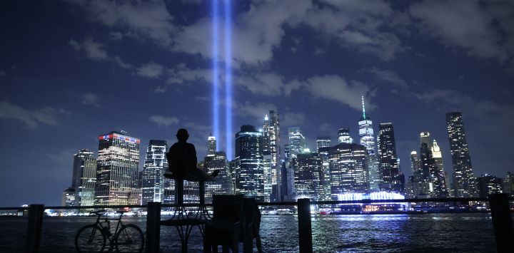 Una persona observa cómo el Tributo en Luz brilla en el cielo desde el Bajo Manhattan durante una prueba en la ciudad de Nueva York. En honor a las víctimas del atentado del 11 de septiembre de 2001 en el que murieron casi 3.000 personas en el World Trade Center, el Tribute in Light es una instalación de arte público conmemorativa que se presentó por primera vez seis meses después del 11-S y luego cada año desde entonces en el aniversario. La ciudad de Nueva York se prepara para conmemorar el 20º aniversario de los atentados terroristas del 11 de septiembre.