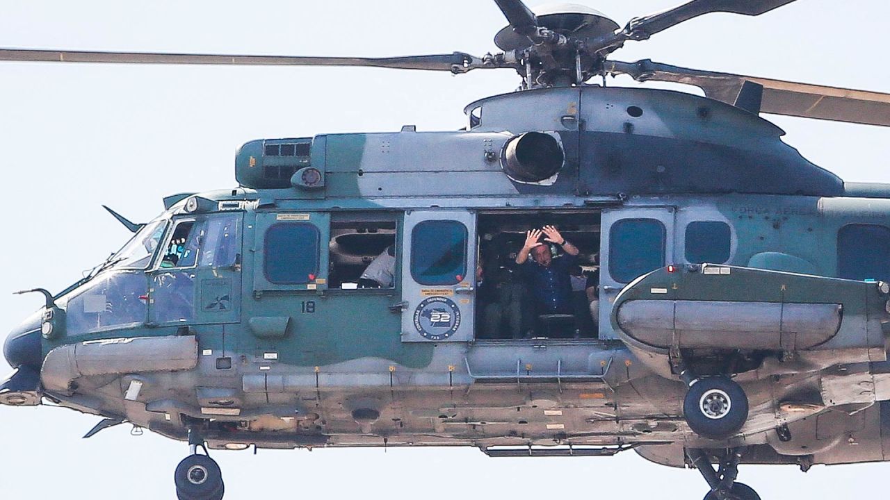 El presidente brasileño Jair Bolsonaro saluda a sus seguidores desde su helicóptero en Brasilia. | Foto:Sergio Lima / AFP