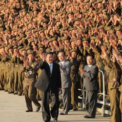 Esta foto muestra al líder norcoreano Kim Jong Un participando en una sesión de fotos con los participantes en el desfile militar en Pyongyang. | Foto:STR / varias fuentes / AFP