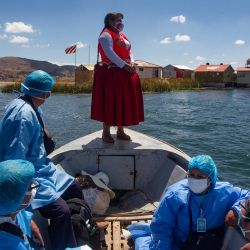 Trabajadores del Ministerio de Salud peruano acompañados por la ex alcaldesa de la isla de Uros, la gestora intercultural Rita Subana, son vistos durante un programa de inmunización de la población vulnerable que aún no ha recibido las vacunas contra el Covid-19 en la isla flotante de Uros en el lago Titicaca, Perú. | Foto:Carlos Mamani / AFP