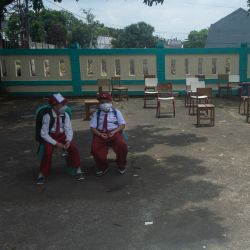 Estudiantes de primaria portan mascarillas mientras esperan para ser recogidos después de la escuela, en Tangerang del Sur, Indonesia. | Foto:Xinhua / Veri Sanovri