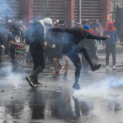Un manifestante devuelve una lata de gas lacrimógeno a la policía antidisturbios durante una marcha en el marco de la conmemoración del 48 aniversario del golpe de Estado, en Santiago, capital de Chile. | Foto:Xinhua / Jorge Villegas