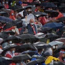 Los espectadores se cubren de la lluvia durante el partido de fútbol de la primera ronda del grupo G de la UEFA Champions League entre el Sevilla y el Salzburgo en el estadio Ramón Sánchez Pizjuán de Sevilla. | Foto:Cristina Quicler / AFP