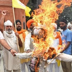 Los agricultores gritan consignas mientras queman una efigie del primer ministro de la India, Narendra Modi, durante una protesta contra las reformas agrícolas del gobierno central, en Amritsar. | Foto:Narinder Nanu / AFP