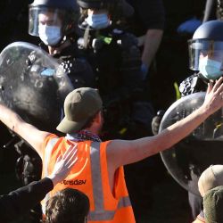 La policía confronta a trabajadores de la construcción y manifestantes con gases lacrimógenos en los escalones del Santuario del Recuerdo durante una protesta contra las regulaciones de Covid-19 en Melbourne.  | Foto:AFP