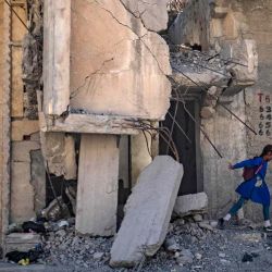 Un estudiante sirio camina hacia la escuela pasando por edificios dañados en la ciudad norteña de Raqqa. | Foto:AFP