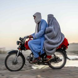 Un hombre y una mujer viajan en motocicleta en Kandahar.  | Foto:AFP