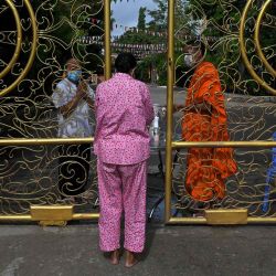 Una mujer ofrece comida y limosna a un monje budista mientras reza durante el festival Pchum Ben (Festival de la Muerte) fuera de una pagoda en Phnom Penh. | Foto:AFP