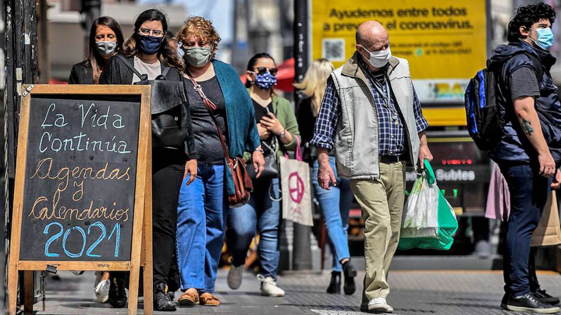 Porteños walk wearing facemasks on the streets of Buenos Aires.