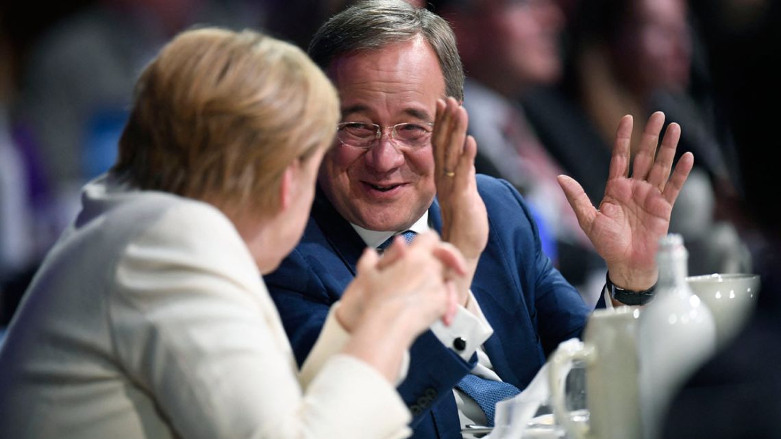 German Chancellor Angela Merkel talks with the leader of Germany's conservative Christian Democratic Union (CDU) and CDU/CSU party union candidate for chancellor Armin Laschet during their last rally in Munich, southern Germany, on September 24, 2021, ahead of the German federal election on September 26. 