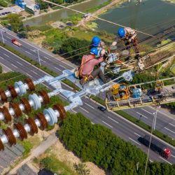 Esta foto muestra a empleados trabajando en una línea de transmisión de corriente continua de alta tensión en Wuxi, en la provincia oriental china de Jiangsu. | Foto:STR / AFP