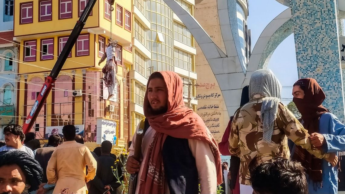 A dead body (top L) displayed in a public area is hanging on a crane in Herat on September 25, 2021, after Taliban killed four kidnappers during a shootout and hanged them, a senior official said.  