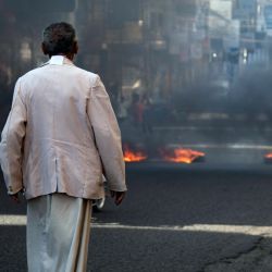 Un hombre yemení mira durante las protestas que reclaman la eliminación del gobierno de coalición respaldado por Arabia Saudí y el deterioro de las condiciones económicas y de vida, en la tercera ciudad de Yemen, Taez. | Foto:Ahmad AL-Basha / AFP