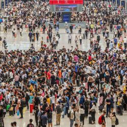 Los pasajeros esperan la llegada de su tren en la estación de tren de Zhengzhou Este en Zhengzhou, en la provincia central china de Henan. | Foto:STR / AFP