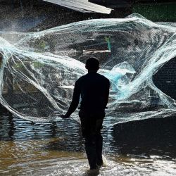 Un residente echa una red para ir a pescar en su pueblo parcialmente sumergido en la provincia central tailandesa de Lopburi, mientras la tormenta tropical Dianmu causaba inundaciones en 30 provincias del país. | Foto:Lillian Suwanrumpha / AFP