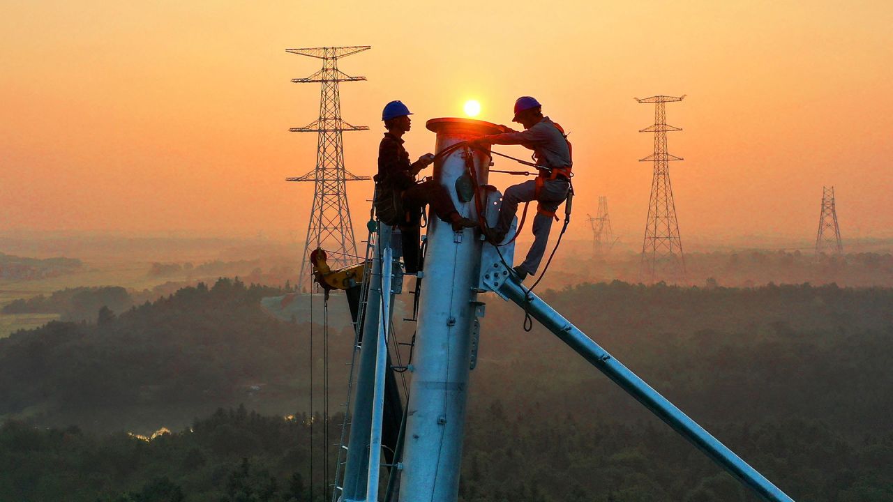 Esta foto muestra a empleados trabajando en una torre de transmisión de alta tensión en Yichun, en la provincia central china de Jiangxi. | Foto:STR / AFP