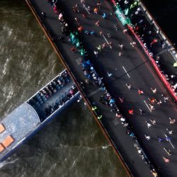 Los competidores corren sobre el Tower Bridge mientras un barco pasa por debajo, mientras compiten en el Maratón de Londres 2021 en el centro de Londres. | Foto:Tolga Akmen / AFP