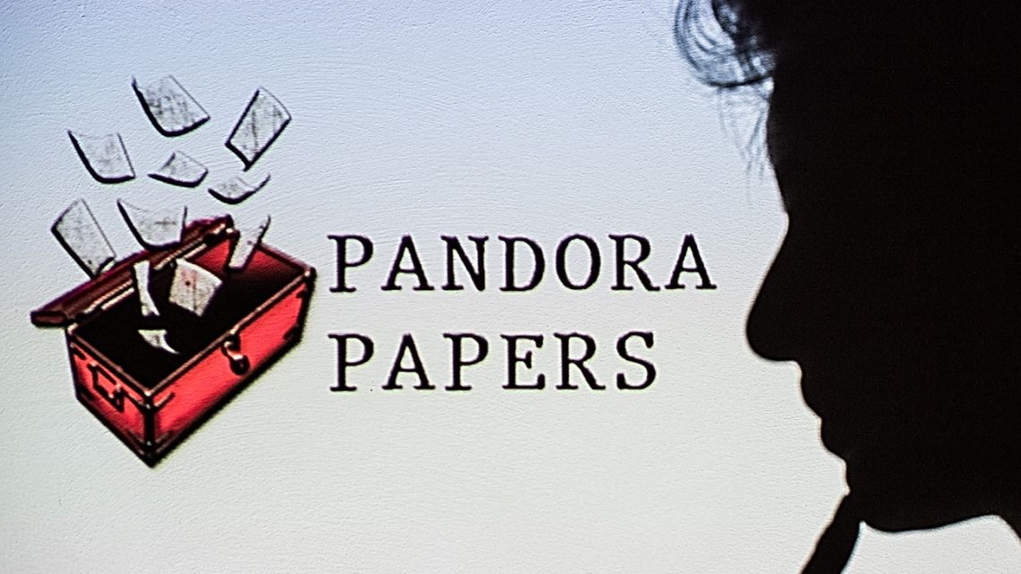 This photograph illustration shows a woman's shadow cast on the logo of Pandora Papers, in Lavau-sur-Loire, western France, on October 4, 2021.