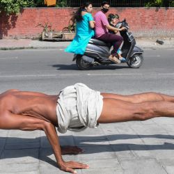 Un hombre practica yoga a lo largo de un sendero en Amritsar. | Foto:Narinder Nanu / AFP