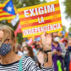 Una manifestante sostiene un cartel con la leyenda "Exigimos la independencia" durante una manifestación en Barcelona. | Foto:Josep Lago / AFP