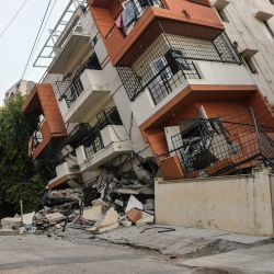 Un miembro del cuerpo de bomberos observa el derrumbe de un edificio de apartamentos de varias plantas, sin que se hayan registrado víctimas, en Bangalore. | Foto:Manjunath Kiran / AFP