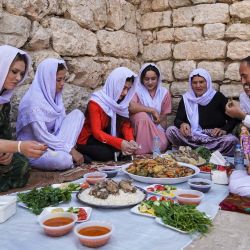 Miembros de la comunidad religiosa yazidí comparten una comida juntos mientras visitan el templo de Lalish, el más sagrado de la fe, en el valle de Lalish, cerca de la ciudad kurda iraquí de Dohuk, durante las celebraciones de la fiesta de la  | Foto:Ismael Adnan / AFP