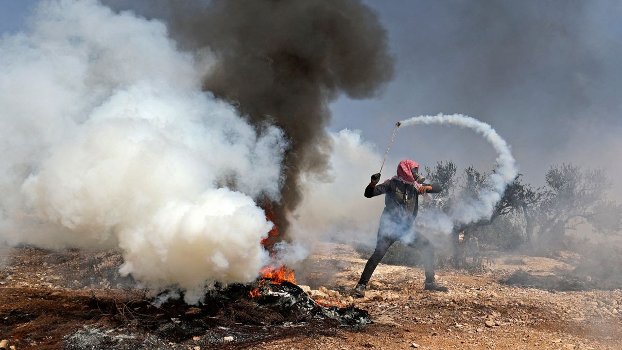 Un manifestante palestino utiliza una gomera para devolver una bomba de gas lacrimógeno hacia las fuerzas de seguridad israelíes durante los enfrentamientos que siguieron a una manifestación contra los asentamientos en el pueblo de Beita, en la Cisjordania ocupada. | Foto:Jaafar Ashtiyeh / AFP