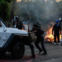 Una persona se manifiesta frente a un vehículo de la policía antimotines durante una protesta, en Santiago, capital de Chile. | Foto:Xinhua/Jorge Villegas