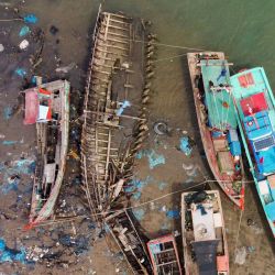 Esta imagen aérea muestra basura, incluyendo residuos de plástico, flotando cerca de los barcos de pesca en la aldea de Pusong en Lhokseumawe. | Foto:AZWAR IPANK / AFP