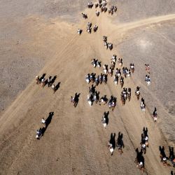 Vista aérea de personas que participan en la cabalgata 'Fiesta de las Fronteras' cerca del histórico monolito de Palou en Playas de Rosarito, estado de Baja California, México. | Foto:Guillermo Arias / AFP
