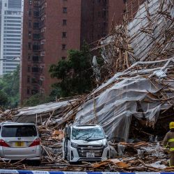 Personal de rescate en el lugar donde un andamio de bambú junto a un edificio residencial de gran altura se derrumbó sobre una carretera, tras los fuertes vientos y las intensas lluvias provocadas por una tormenta tropical, en Hong Kong. | Foto:ISAAC LAWRENCE / AFP