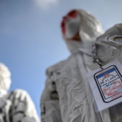 Los manifestantes llevan máscaras y trajes de protección total mientras se manifiestan en Ginebra, durante una concentración contra las medidas contra el coronavirus, el pase sanitario Covid-19 y la vacunación. | Foto:Fabrice Coffrini / AFP