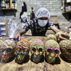 Un trabajador acomoda calaveras artesanales a base de semillas con motivo del Día de Muertos previo a su celebración, en un taller de elaboración de dulces artesanales, en la Ciudad de México, capital de México. | Foto:Xinhua/Patricia Olivares