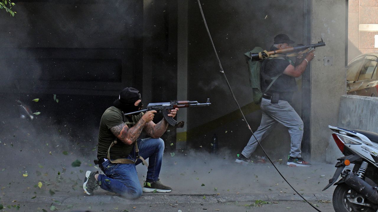 Combatientes chiíes de los movimientos Hezbolá y Amal apuntan con un fusil de asalto Kalashnikov y un lanzagranadas propulsado por cohetes en medio de enfrentamientos en la zona de Tayouneh, en el suburbio sur de la capital Beirut. | Foto:IBRAHIM AMRO / AFP