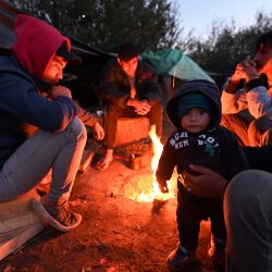 Personas afganas reunidas en torno a una fogata en un campamento ilegal improvisado, a las afueras de la ciudad fronteriza de Velika Kladusa, en el norte de Bosnia. | Foto:ELVIS BARUKCIC / AFP