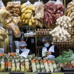 Trabajadoras preparan verduras para su venta en un puesto del mercado "Virgen de las Mercedes", en el distrito de Lurín, en el sur de Lima, Perú. | Foto:Xinhua/Mariana Bazo