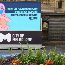 Una mujer se sienta en el exterior de un centro de vacunación en Melbourne, antes del esperado levantamiento de las restricciones por coronavirus en una de las ciudades más cerradas del mundo. | Foto:William West / AFP