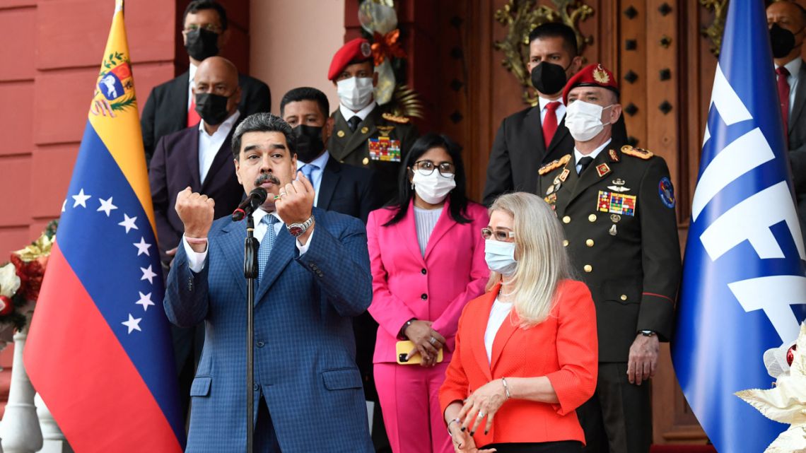 Venezuelan President Nicolás Maduro gestures as he speaks with the press next to First Lady Cilia Flores and Vice-President Delcy Rodríguez after holding a meeting with FIFA president Gianni Infantino (out of frame) at the Miraflores Presidential Palace in Caracas, on October 15, 2021.