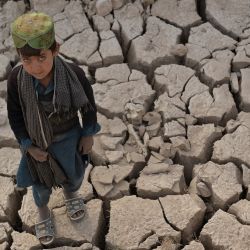 Esta foto muestra a un niño de pie sobre una tierra seca en el distrito de Bala Murghab de la provincia de Badghis. - La sequía acecha los campos resecos que rodean el remoto distrito afgano de Bala Murghab, donde el cambio climático está resultando un enemigo más mortífero que los recientes conflictos del país. | Foto:Hoshang Hashimi / AFP