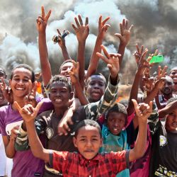 Jóvenes sudaneses muestran signos de victoria junto a una barricada hecha de neumáticos quemados en la capital, Jartum, mientras protestan contra el golpe militar que anuló la transición al gobierno civil. | Foto:AFP