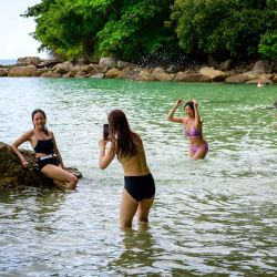Una foto muestra a personas tomando fotos mientras juegan en una playa de la isla tailandesa de Phuket. | Foto:MLADEN ANTONOV / AFP