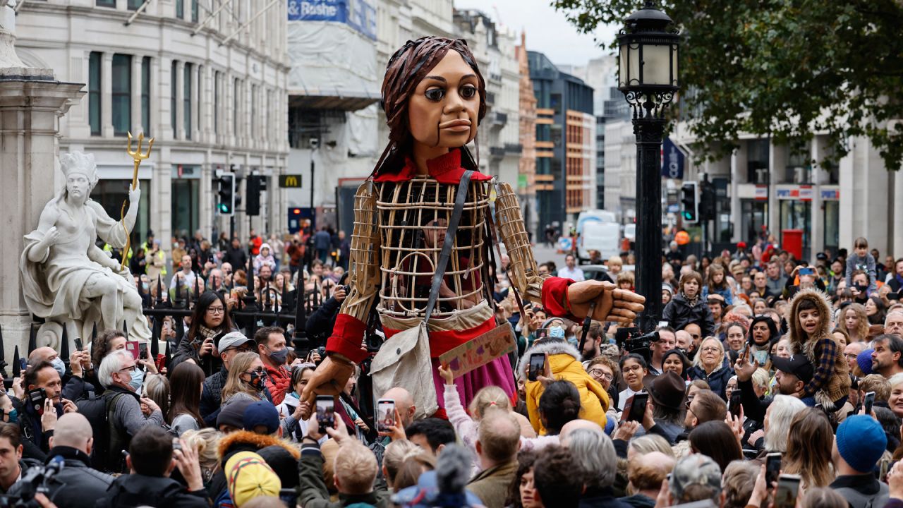 La pequeña Amal, una marioneta gigante que representa a una niña refugiada siria, llega a la catedral de San Pablo en la ciudad de Londres, como parte del proyecto artístico internacional The Walk. | Foto:Tolga Akmen / AFP
