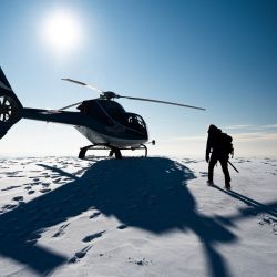 La investigadora Ninis Rosqvist camina hacia el helicóptero después de visitar el pico de la cima sur del Kebnekaise, en el norte de Suecia, para tomar mediciones con GPS sobre la altura de la montaña. | Foto:JONATHAN NACKSTRAND / AFP