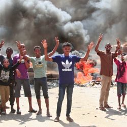 Jóvenes sudaneses muestran signos de victoria junto a una barricada hecha de neumáticos ardiendo en la capital, Jartum, mientras protestan contra el golpe de Estado militar que anuló la transición al gobierno civil. | Foto:AFP